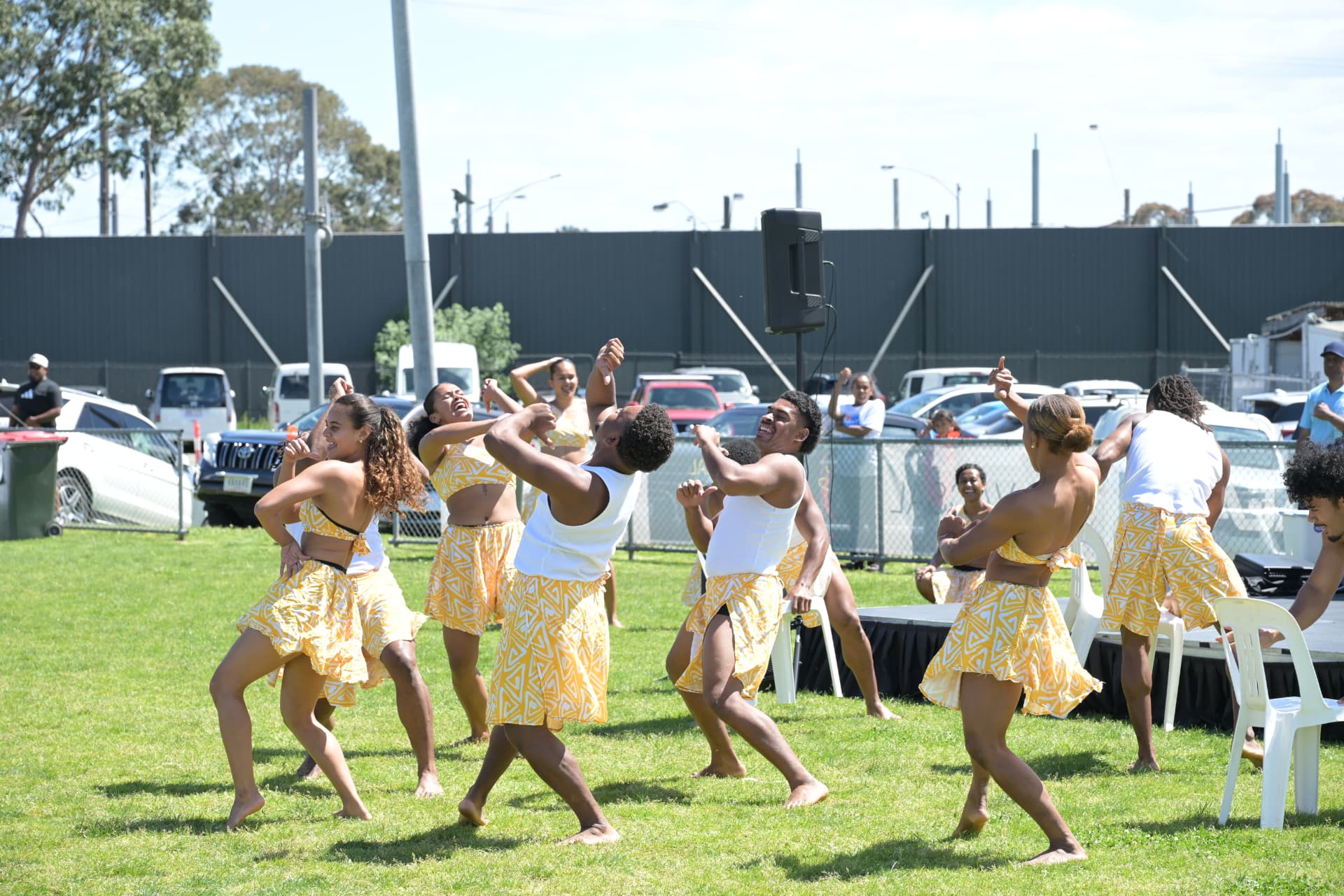 Young dancers perform an animated routine on the grass in front of the stage at Fiji Day 2026